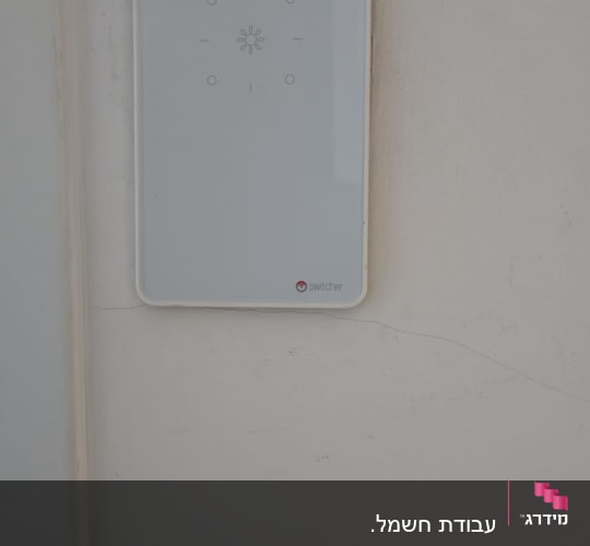 מתג חכם על קיר לבן עם לוח בקרה